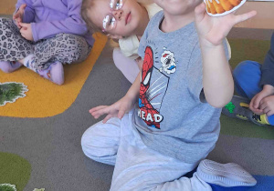 Dziecko pokazuje co należy włożyć do koszyczka wielkanocnego