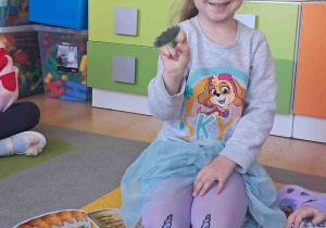 Dziecko pokazuje co należy włożyć do koszyczka wielkanocnego