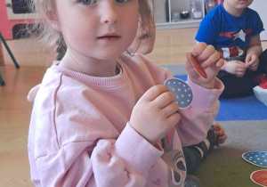 Dziecko pokazuje co należy włożyć do koszyczka wielkanocnego