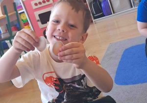 Dziecko pokazuje co należy włożyć do koszyczka wielkanocnego