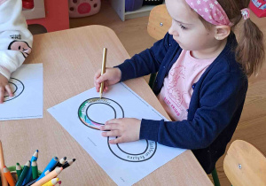 Dzieci przy stoliku kolorują znak nieskończoności