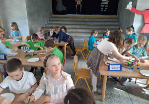 Dzieci wykonują zadania przy stoliczkach