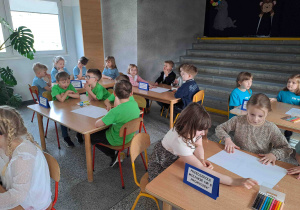 Dzieci wykonują zadania przy stoliczkach