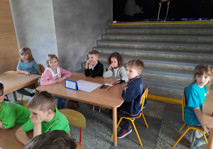 Dzieci wykonują zadania przy stoliczkach