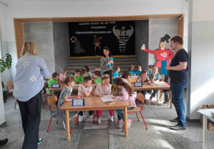 Dzieci wykonują zadania przy stoliczkach