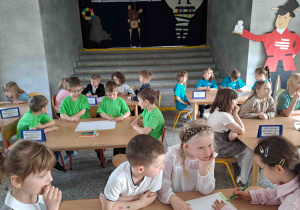 Dzieci wykonują zadania przy stoliczkach