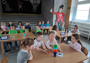 Dzieci układają konstrukcje z kolorowych kubeczków