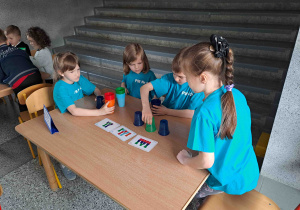 Dzieci układają konstrukcje z kolorowych kubeczków