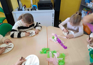 Dzieci wykonują pracę plastyczną "Kwitnące drzewko" z wykorzystaniem talerzyków papierowych i kolorowej bibuły