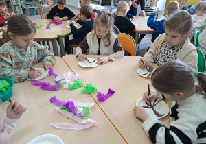 Dzieci wykonują pracę plastyczną "Kwitnące drzewko" z wykorzystaniem talerzyków papierowych i kolorowej bibuły