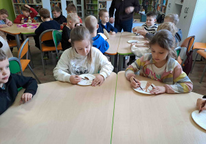 Dzieci wykonują pracę plastyczną "Kwitnące drzewko" z wykorzystaniem talerzyków papierowych i kolorowej bibuły