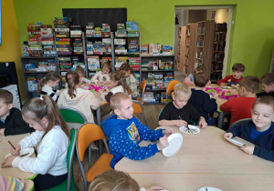 Dzieci wykonują pracę plastyczną "Kwitnące drzewko" z wykorzystaniem talerzyków papierowych i kolorowej bibuły