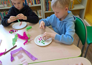 Dzieci wykonują pracę plastyczną "Kwitnące drzewko" z wykorzystaniem talerzyków papierowych i kolorowej bibuły