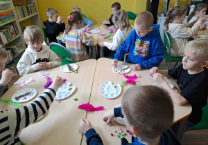 Dzieci wykonują pracę plastyczną "Kwitnące drzewko" z wykorzystaniem talerzyków papierowych i kolorowej bibuły