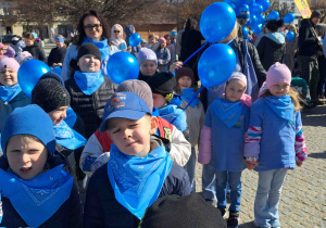 Dzieci ubrane na niebiesko biorą udział w przemarszu