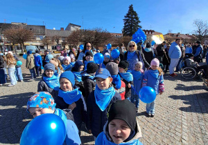 Dzieci ubrane na niebiesko biorą udział w przemarszu