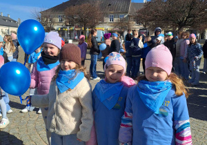 Dzieci ubrane na niebiesko biorą udział w przemarszu