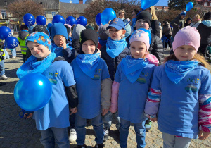 Dzieci ubrane na niebiesko biorą udział w przemarszu