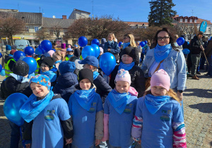 Dzieci ubrane na niebiesko biorą udział w przemarszu