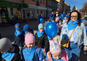 Dzieci ubrane na niebiesko biorą udział w przemarszu