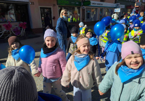 Dzieci ubrane na niebiesko biorą udział w przemarszu