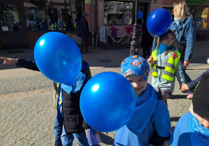 Dzieci ubrane na niebiesko biorą udział w przemarszu