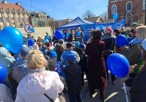 Dzieci ubrane na niebiesko biorą udział w przemarszu