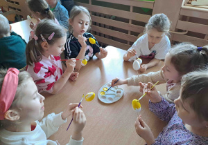 Dzieci malują na żółto styropianowe jajeczka