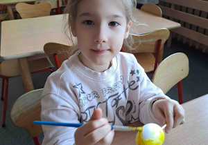 Dzieci malują na żółto styropianowe jajeczka