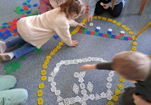 Dzieci układają na podłodze pisanki - giganty z klocków