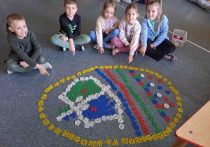 Dzieci układają na podłodze pisanki - giganty z klocków