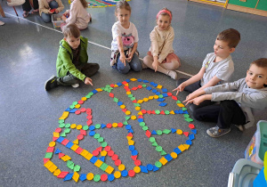 Dzieci układają na podłodze pisanki - giganty z klocków
