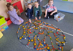 Dzieci układają na podłodze pisanki - giganty z klocków