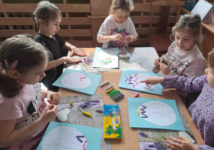 Dzieci tworzą wzorki z wałeczków plasteliny na konturach pisanek