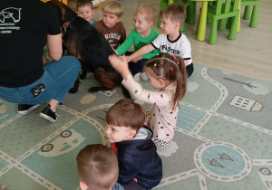 Dzieci siedzą na dywanie