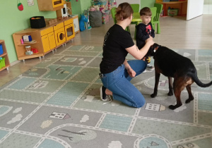 Pani stoi przy przy chłopcu z psem