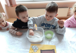 Dzieci odmierzają cukier zawarty w słodkim batonie