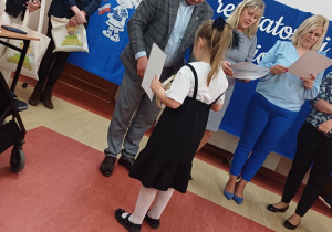 Dziewczynka odbiera dyplom z rąk Wójta Gminy Łanięta