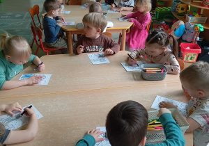 Dzieci kolorują kolorowankę z psem