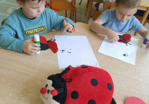 Dzieci wykonują prace plastyczną - biedronke