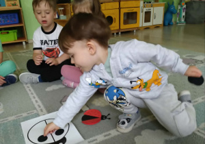 Chłopiec układa kropki na biedronce