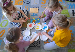 Dzieci w zespołach wykonują zadania matematyczne