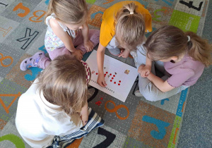Dzieci w zespołach wykonują zadania matematyczne