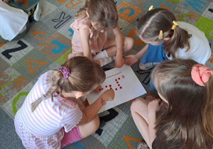 Dzieci w zespołach wykonują zadania matematyczne