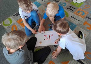 Dzieci w zespołach wykonują zadania matematyczne