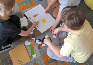 Dzieci w zespołach wykonują zadania matematyczne