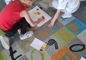 Dzieci w zespołach wykonują zadania matematyczne
