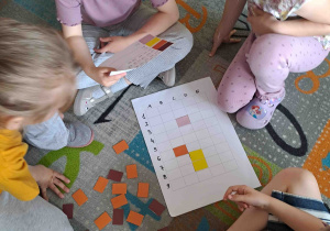 Dzieci w zespołach wykonują zadania matematyczne