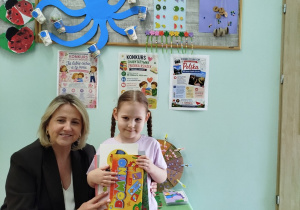 Pani Wicedyrektor wręcza dziewczynce nagrodę i dyplom