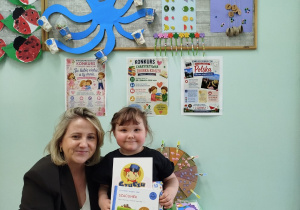 Pani Wicedyrektor wręcza dyplom i nagrodę w postaci książki i gry